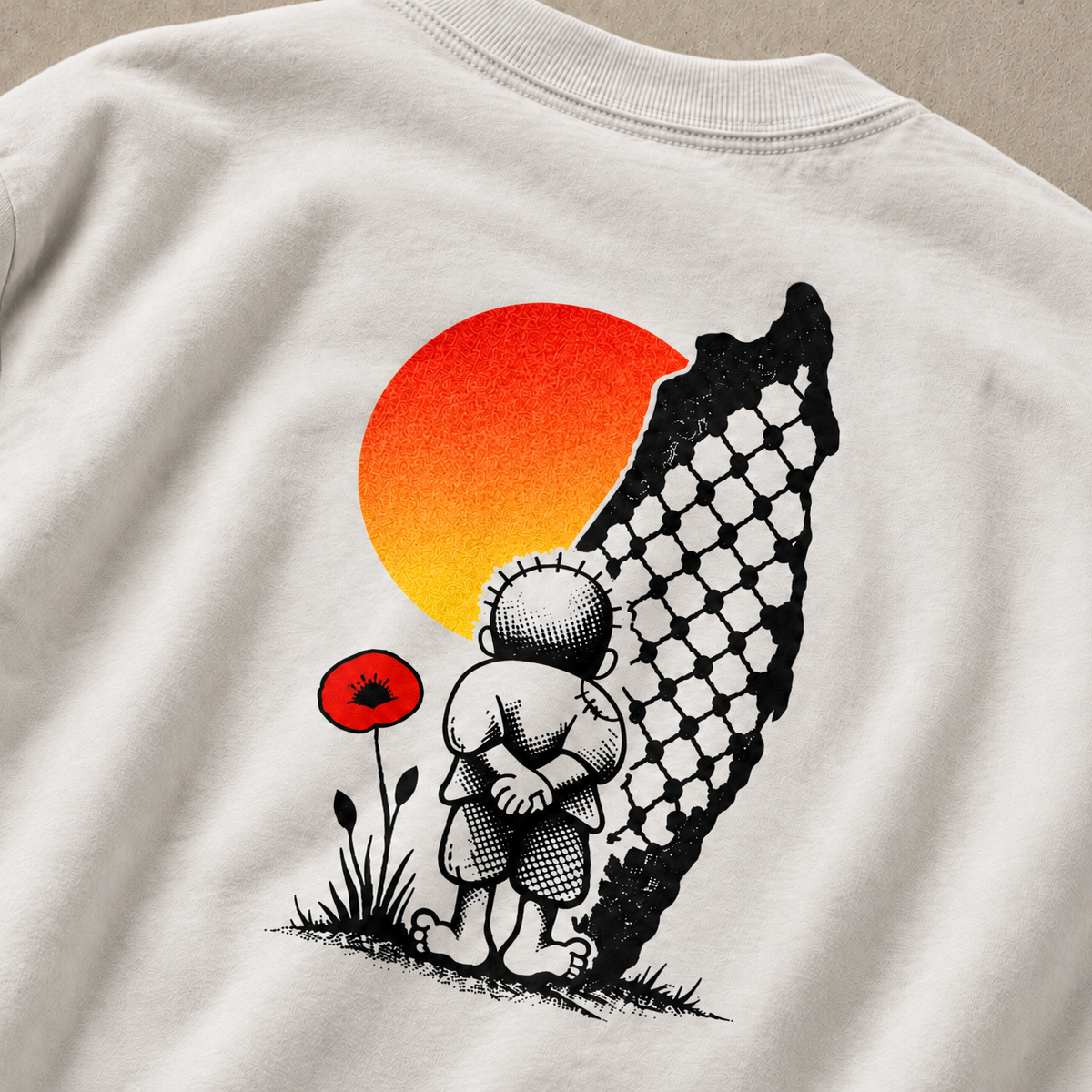 Close-up of the back artwork on a Faded Bone Handala heavyweight Palestinian shirt, featuring Naji al-Ali’s Handala figure, a Palestine-shaped keffiyeh pattern, orange sun, and red poppy.