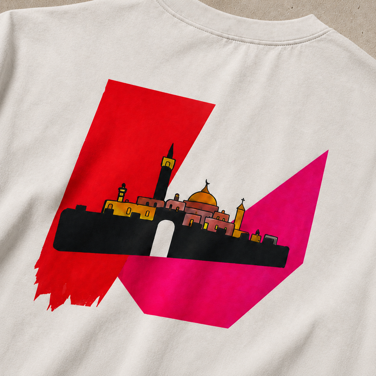 Close-up back view of a Faded Bone In Jerusalem heavyweight Palestinian shirt featuring a stylized Jerusalem skyline in black, gold and pink over bold red and magenta geometric artwork.