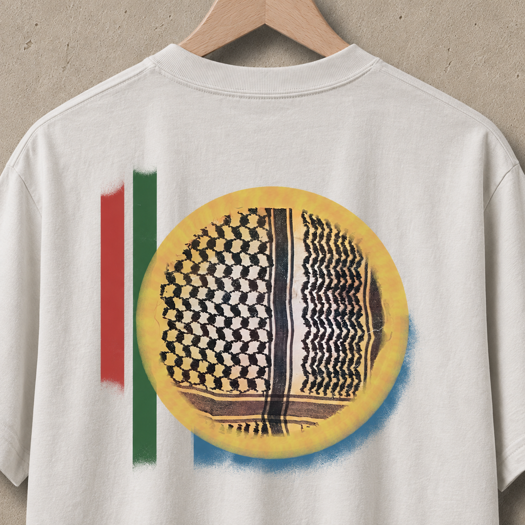 Close-up of the Keffiyeh Sun heavyweight faded bone shirt artwork featuring a black Palestinian keffiyeh pattern inside a yellow sun with red and green graphic accents.