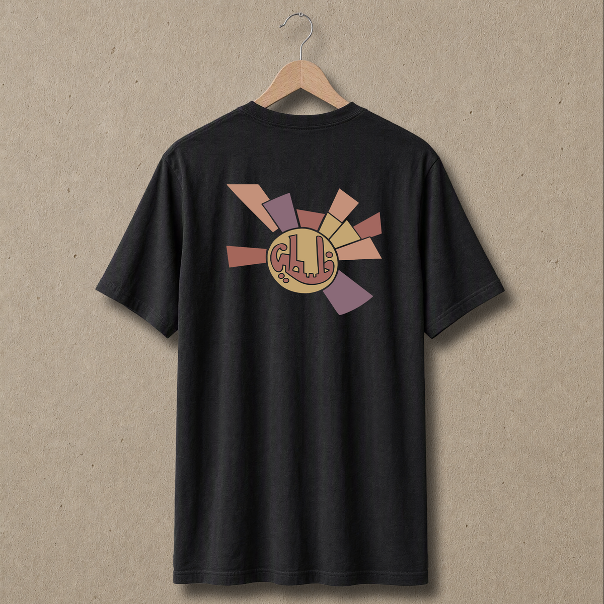 Sun Emblem artwork on the back of a regular fit black Palestinian T-shirt hanging on a wooden hanger.